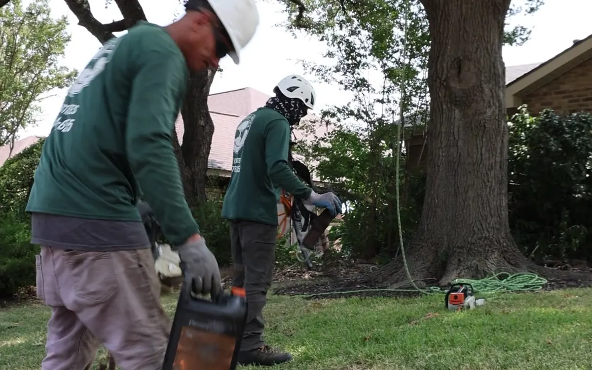 Ram Tree Service crew fueling and staging grinding equipment on a DFW job site
